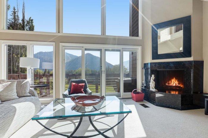 A living room with tall windows and a fireplace edited by AutoHDR V3