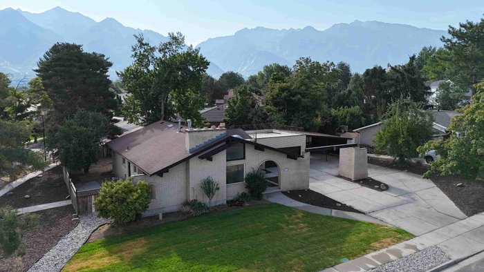 Mid bracket exposure of an aerial view of a home below the mountains