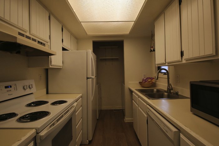 Mid bracket exposure of a galley kitchen with white cabinets and a skylight