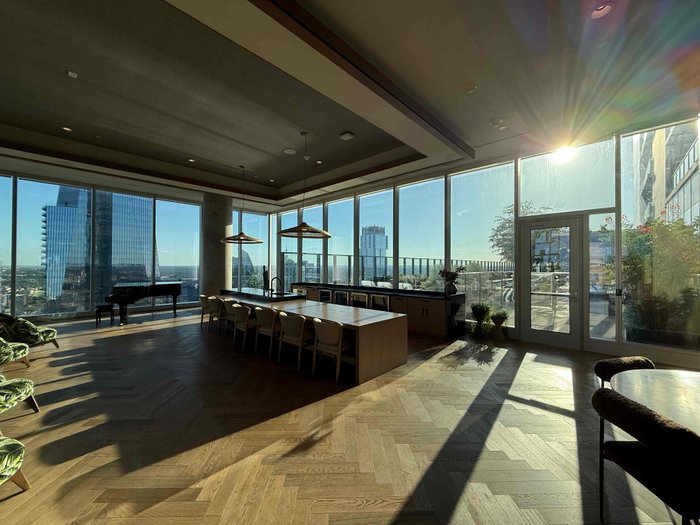 Single bracket iPhone shot of a penthouse lounge with floor-to-ceiling windows, unedited